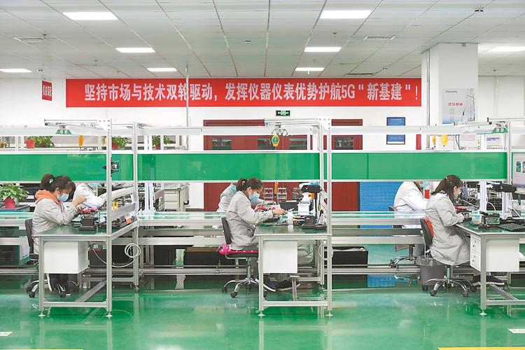 蚌埠依爱电子科技有限责任公司车间流水线上,工人正在对电子产品进行